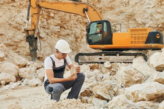 Operator is working on the borrow pit. Man in professional uniform.