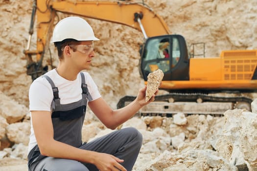 Professional occupation. Worker in uniform is on the borrow pit at daytime.