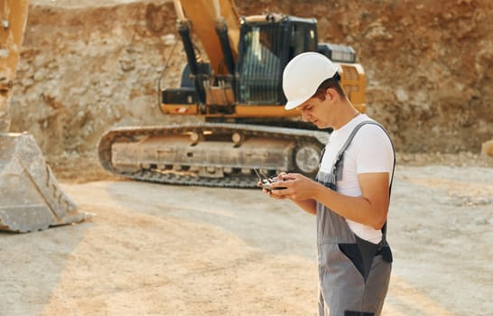 Professional occupation. Worker in uniform is on the borrow pit at daytime.