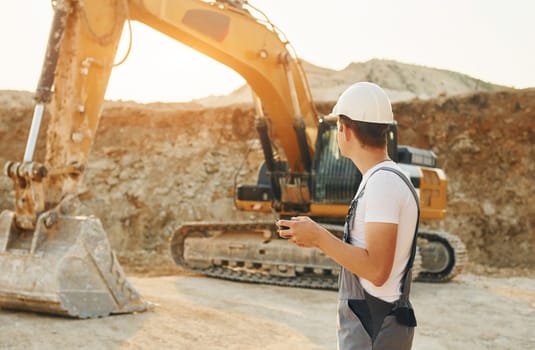 Professional occupation. Worker in uniform is on the borrow pit at daytime.