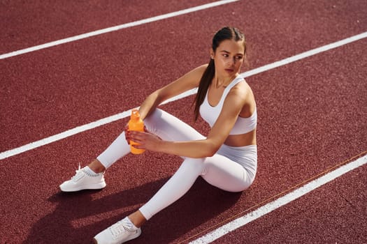 Conception of bodycare. Young woman in sportive clothes is exercising outdoors.