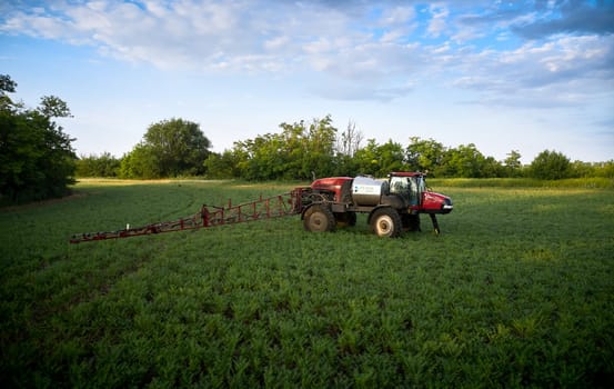 Sprayer CASE 3330 spraying pesticides on chickpea field. Field treatment with chemicals against pests, insects and plant diseases. Taking care of the Crop. 21.06.22, Rostov area. Russia