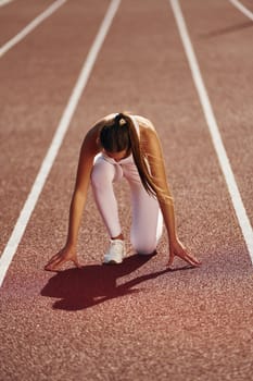 Woman in sportive clothes is exercising outdoors.