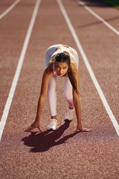 Woman in sportive clothes is exercising outdoors.