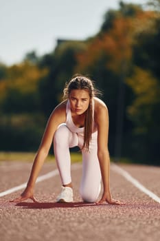 Woman in sportive clothes is exercising outdoors.