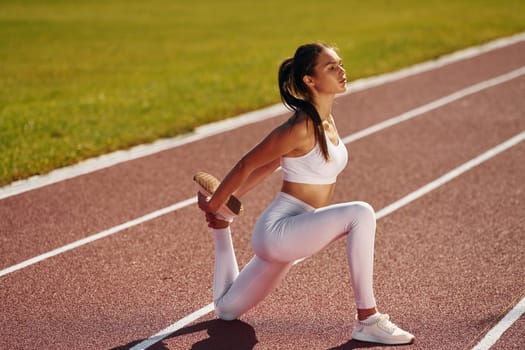 Focused athlete. Young woman in sportive clothes is exercising outdoors.