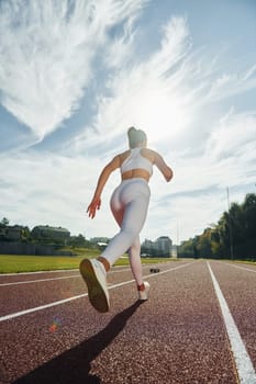 Active young woman in sportive clothes is exercising outdoors.