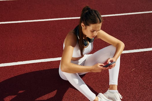 Tired, taking break. Young woman in sportive clothes is exercising outdoors.