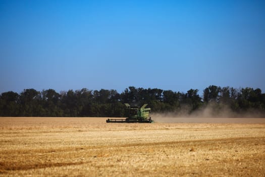 John Deere harvester works in the field. Combine Harvesting Wheat. Field field of cereals during harvesting. Modern equipment works. 07.07.22, Rostov region, Russia.