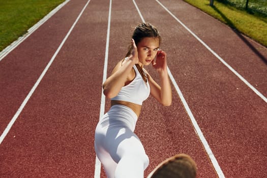 Practicing fight techniques. Young woman in sportive clothes is exercising outdoors.