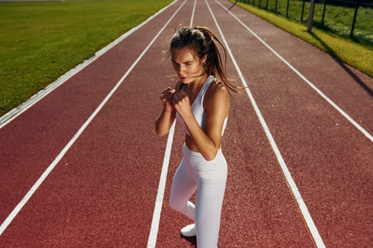 Practicing fight techniques. Young woman in sportive clothes is exercising outdoors.
