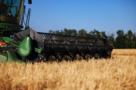 John Deere harvester works in the field. Combine Harvesting Wheat. Field field of cereals during harvesting. Modern equipment works. 07.07.22, Rostov region, Russia.