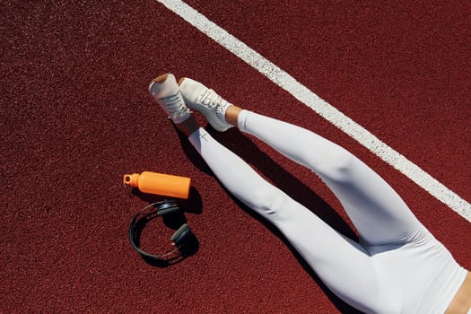 Stretching and strength exercises. Young woman in sportive clothes is exercising outdoors.