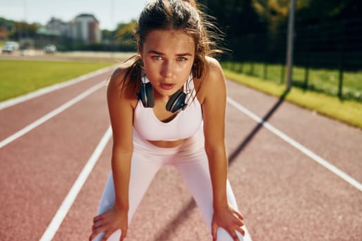 Young woman in sportive clothes is exercising outdoors.