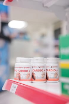 Cardiology pills bottle standing on drugstore shelves ready for clients to come and buy drugs and vitamins. Pharmacy carried a range of products, from prescription pills to home healthcare items.
