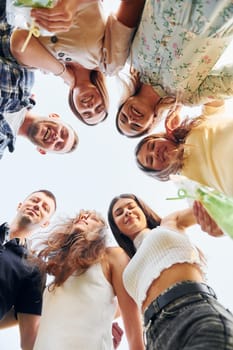 View from below of young positive people that looking down.