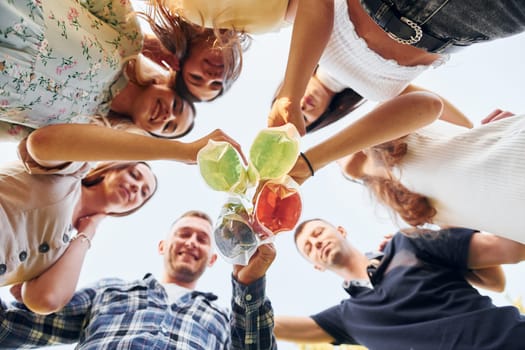 View from below of young positive people that looking down.