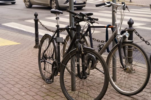 Bicycle parking. Bicycles stand next to each other, in the background are roads and cars.