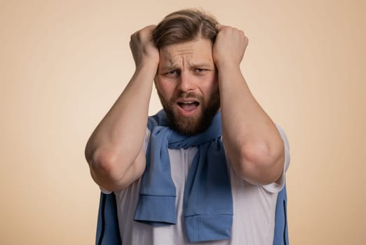 Bearded caucasian man feeling hopelessness loneliness, nervous breakdown, loses becoming surprised by lottery results, bad fortune loss, unlucky news. Young guy isolated on studio beige background