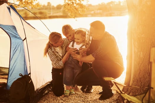Beautiful sunlight. Family of mother, father and kids is on the camping.