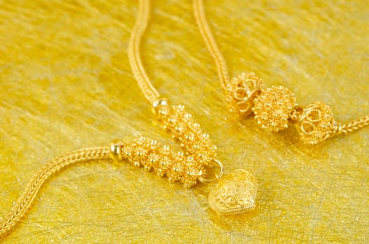 Gold necklace on gold color background.
