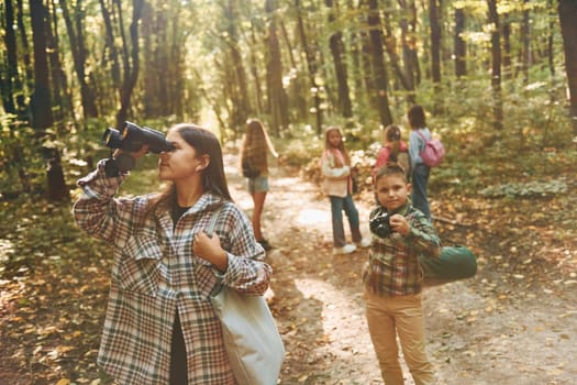 Discovering new places. Kids in green forest at summer daytime together.