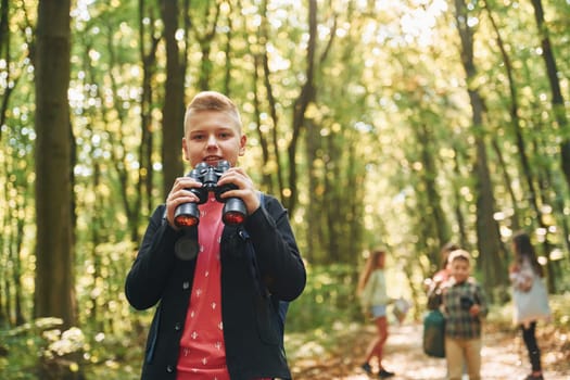 Founding the way. Kids in green forest at summer daytime together.