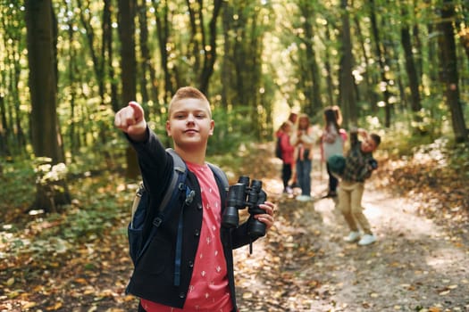 Founding the way. Kids in green forest at summer daytime together.