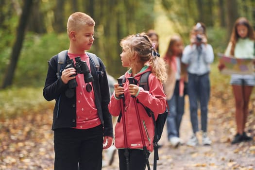 Group of people. Kids in green forest at summer daytime together.