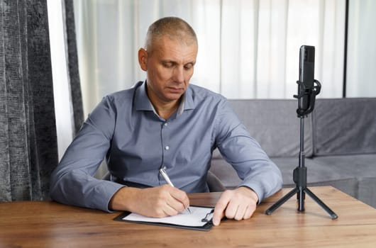 Businessman, psychologist communicates with the Internet audience using a smartphone. Video blogger broadcasts via smartphone.