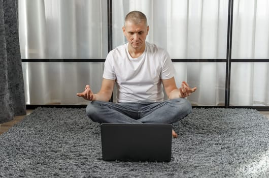 A middle-aged man conducts remote training in yoga, psychosomatics. Vacation and health concept.