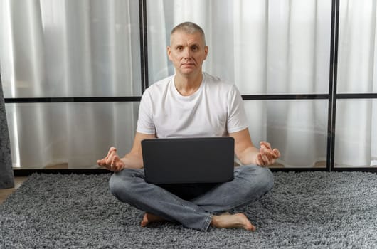 A middle-aged man conducts remote training in yoga, psychosomatics. Vacation and health concept.