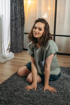 Portrait of a beautiful woman who is sitting indoors on the floor.