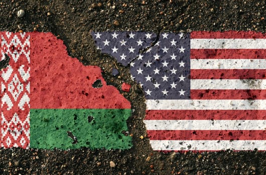 On the pavement there are images of the flags of Belarus and the USA, as a symbol of the confrontation between the two countries. Conceptual image.