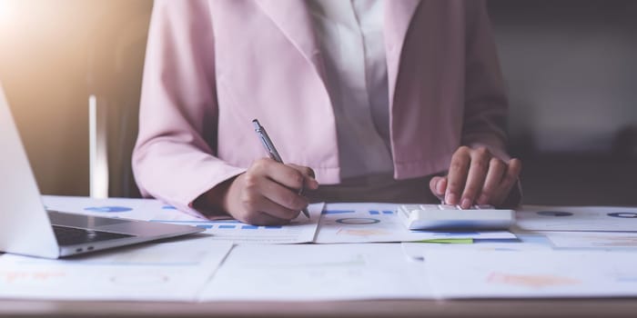 Asian Business person makes analysis and research financial report at office, analyzes profits. Accountant checks status of financial.