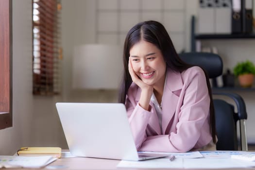 Asian Business person makes analysis and research financial report at office, analyzes profits. Accountant checks status of financial.