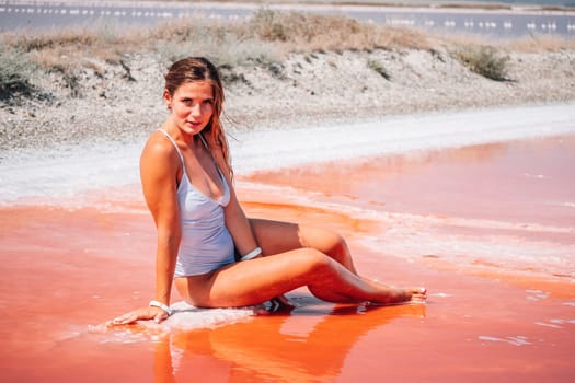 Salt mining. Salty pink lake with crystals of salt. Extremely salty pink lake, colored by microalgae with crystalline salt depositions