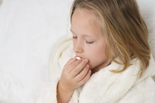 A girl takes a thermometer from the table where the medicines are. Medical concept.