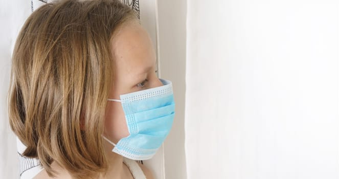 Sick teenage girl in a protective mask looks away. Medical concept.