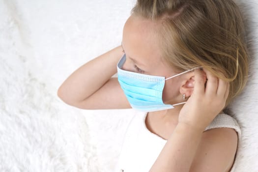 Sick teenage girl wears a medical protective mask. Medical concept.