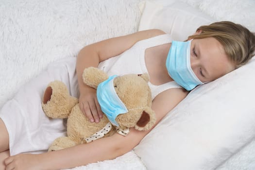 A sick teenage girl is playing with a toy wearing a protective mask. Medical concept.