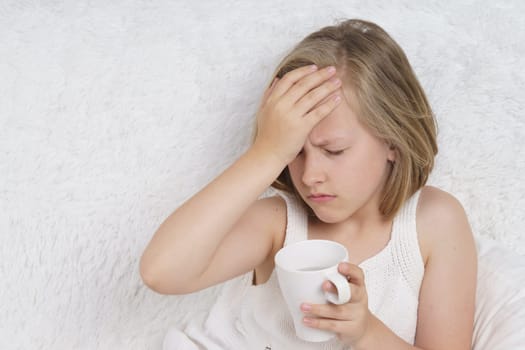 A sick teenage girl clings to her head. Medical concept.