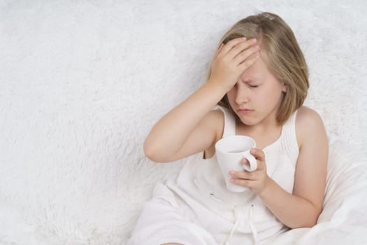 A sick teenage girl clings to her head. Medical concept.