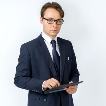 Portrait of a businessman in a blue suit holding an electronic tablet on a white background. Business and finance concept