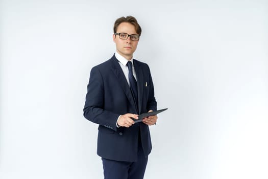 Portrait of a businessman in a blue suit holding an electronic tablet on a white background. No face visible. Business and finance concept