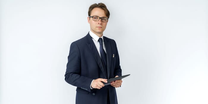 Portrait of a businessman in a blue suit holding an electronic tablet on a white background. No face visible. Business and finance concept