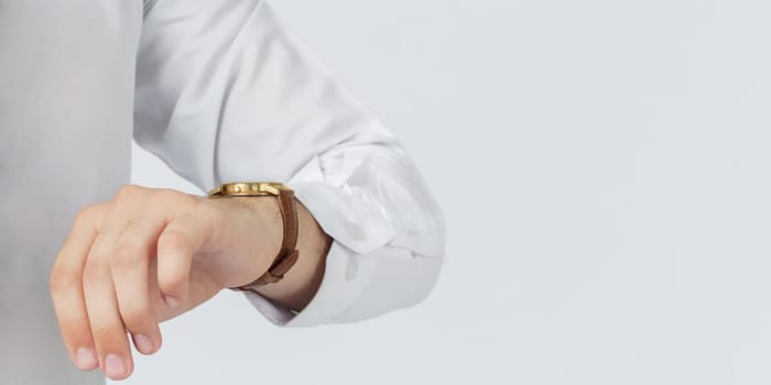 The businessman looks at his watch. White background. Business and finance concept