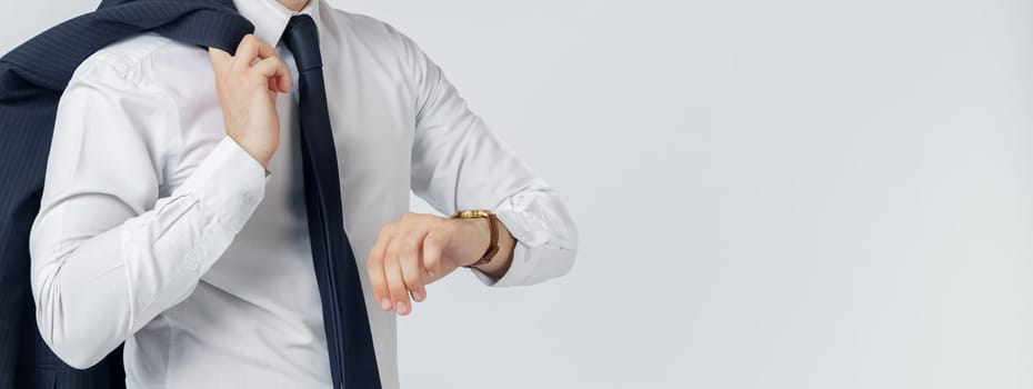 Portrait of a businessman in a blue suit who looks at his watch. No face visible. White background. Business and finance concept