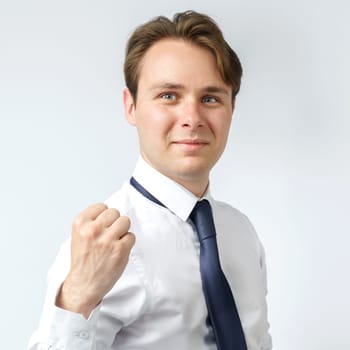 Portrait of a businessman raised his hand clenched into a fist. White background. Business and finance concept