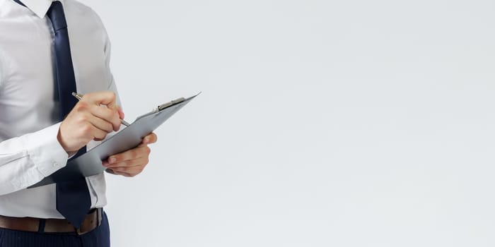 Businessman in a blue suit holds a folder in his hands on a white background. No face visible. Business and finance concept